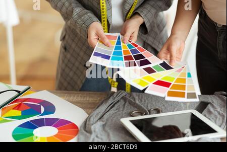 Stilista di moda femminile e cliente che tiene campioni di colore Foto Stock