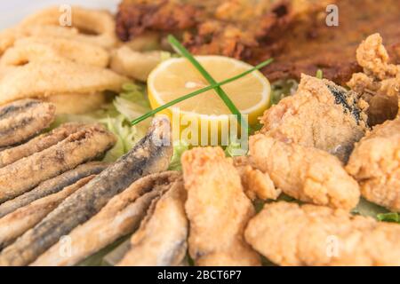 Piatto di pesce fritto con acciughe, calamari, marinata e frittelle di gamberi. Foto Stock