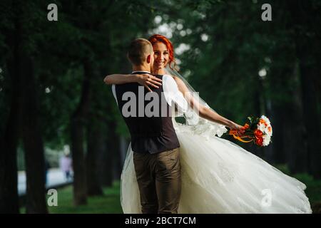 L'uomo dopo il matrimonio gira con la moglie nelle sue mani nel vicolo oscuro Foto Stock