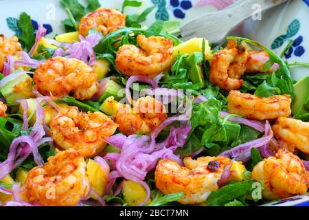 Insalata verde fresca con gamberi anneriti, cipolle rosse sottaceto e ananas in una ciotola Foto Stock