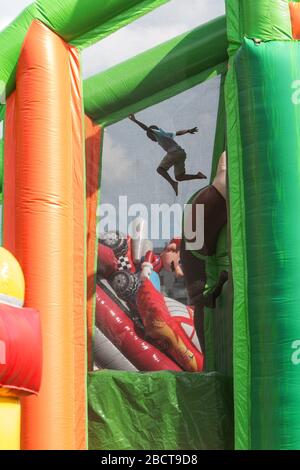 Un ragazzo salta in una fossa di plastica da un'altezza di due piani su un gonfiabile gigante al Fun Day at the Park, al Piedmont Park il 10 agosto 2019 ad Atlanta. Foto Stock