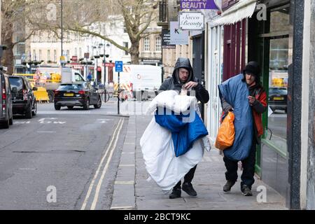 Bath, North Somerset, Regno Unito. 31st marzo 2020. Due senzatetto camminano per le strade durante il blocco nel centro di Bath stipando la loro biancheria da letto e pers Foto Stock