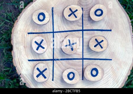 tic tac toe game su un tavolo di legno con tac toe e croci di legno. strategia vincente, abilità vincente, visione di un'idea, capacità di guidare, successo strato Foto Stock