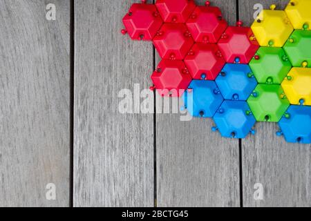 Concetto di pensiero creativo e logico. Diversi blocchi colorati su sfondo grigio legno, disposizione piatta, spazio copia. Esagonale geometrico di colore diverso Foto Stock