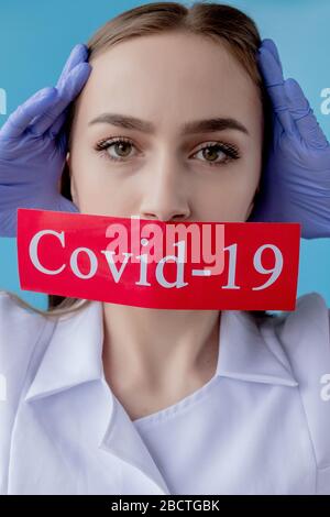 Medico donna che indica carta rossa con mesaage Coronavirus su sfondo blu. Organizzazione Mondiale della Sanità CHE ha introdotto un nuovo nome ufficiale per Foto Stock