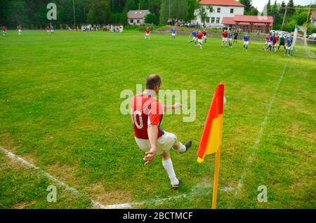 Giocatore di calcio sul campo verde durante la partita locale di domenica. Foto Stock