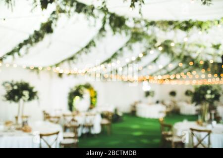 Festa di nozze serale o festa di fiera notturna con luci sfocate bokeh per l'uso dello sfondo. Decorazioni per matrimoni. Foto Stock