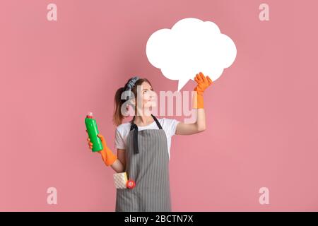 Allegra casalinga che indossa grembiule e guanti per famiglie, tenendo vuoto Speech Bubble Foto Stock