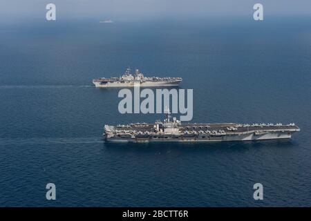 La nave portaerei USS Dwight D. Eisenhower della classe Nimitz della marina statunitense e la nave d'assalto anfibia USS Bataan transitano fianco a fianco 2 aprile 2020 nel Mar Arabico. Foto Stock