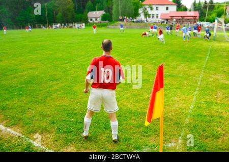 Giocatore di calcio sul campo verde durante la partita locale di domenica. Foto Stock