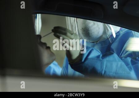 Illinois National Guard Medical staff tampona un paziente per COVID-19, coronavirus screening presso un centro di test drive up del 24 marzo 2020 a Chicago, Illinois. Foto Stock