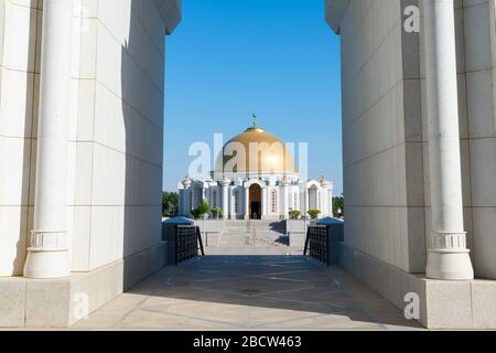 Mausoleo di Saparmurat Niyazov nel villaggio di Gypjak ad Ashgabat, Turkmenistan, tra le colonne di pietra della moschea. Cupola in marmo bianco e oro. Foto Stock