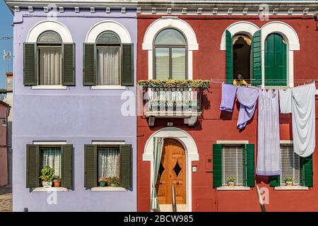 Lavaggio appeso ad asciugare da case colorate sull'isola italiana di Burano An Island nella laguna veneta, Venezia, Italia Foto Stock