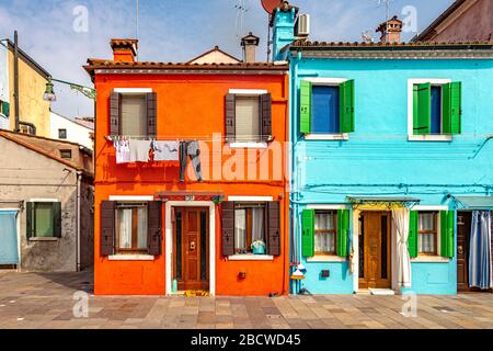 Lavaggio appeso ad asciugare da case colorate sull'isola italiana di Burano An Island nella laguna veneta, Venezia, Italia Foto Stock