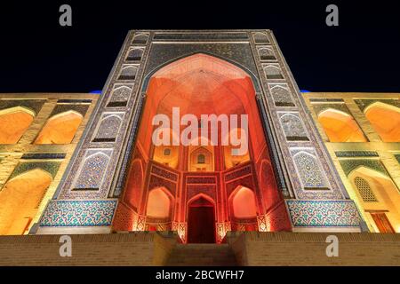 Miri Arab Madrasah illuminato di notte al complesso poi Kalan a Bukhara, Uzbekistan. Anche conosciuto come Mir-i madrassah arabo. Iwan di madrasa in Via della Seta. Foto Stock