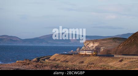 Treno ferroviario nord di classe 156 sprinter ad Harrington sulla linea ferroviaria panoramica della costa Cumbria che corre lungo il mare irlandese con Solway Firth Beyond Foto Stock