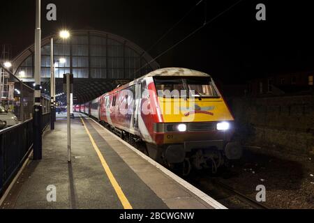 LNER classe 91 locomotiva elettrica 91101 Flying Scotsman alla stazione ferroviaria di Darlington sulla linea principale della costa orientale di notte. Foto Stock