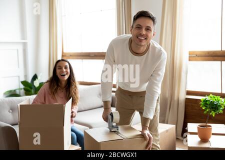 Giovane coppia di famiglia eccitato che prepara le cose roba per la consegna. Foto Stock
