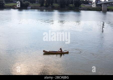 SREMSKA MITROVICA, SERBIA - 24 SETTEMBRE 2016: Vecchio rematore con la sua canoa sul fiume Sava nella città di Sremska Mitrovica, nel nord della Serbia Foto Stock