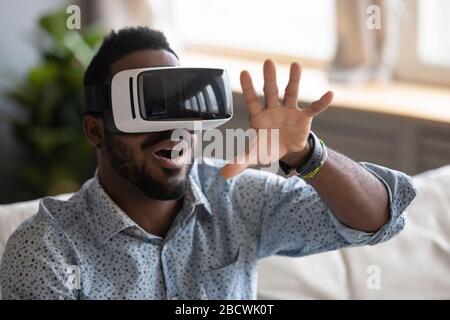 L'uomo afro-americano ha divertenti occhiali di prova VR Foto Stock