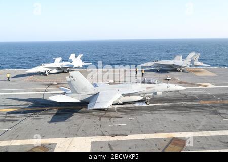 Un aereo da combattimento statunitense F/A-18E Hornet attaccato ai leoni dello Strike Fighter Squadron 213, atterra sul ponte di volo della portaerei della classe Ford USS Gerald R. Ford in corso di svolgimento della sua piattaforma di volo e di lotta contro la certificazione del centro di controllo del traffico aereo 19 marzo 2020 nell'Oceano Atlantico. Foto Stock