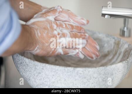 Giovane uomo caucasico responsabile pulendo le mani con sapone antibatterico. Foto Stock