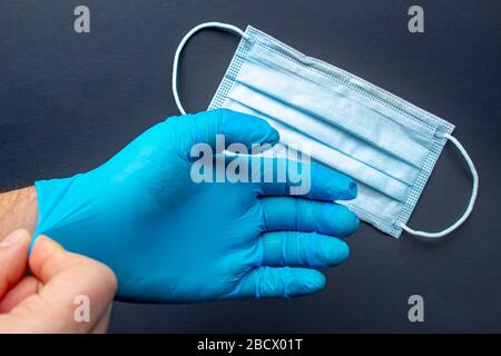 Un soccorritore medico che indossa guanti e maschera facciale Foto Stock