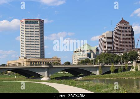 Vista magnifica dello skyline del centro di Columbus, Ohio, il ponte largo del fiume Scioto, costruzione di strade, parco di Genova e sentiero a piedi del parco Alexander Foto Stock