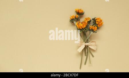 Bouquet di girasoli gialli secchi su sfondo beige. Composizione floreale, disposizione piatta, vista dall'alto, spazio di copia Foto Stock