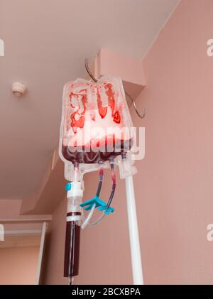 Trasfusione di sangue nella fase finale dell'operazione. Svuotare quasi il sacchetto di sangue su una rastrelliera. Foto verticale Foto Stock