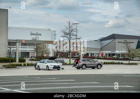 Persone che praticano la distanza sociale sicura a causa di Coronavirus Covid-19 nel parcheggio di parcheggio chiuso King of Prussia Mall, Pennsylvania, Stati Uniti Foto Stock