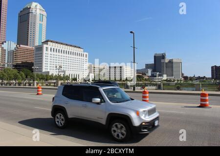 Vista magnifica dello skyline del centro di Columbus, Ohio, il ponte largo del fiume Scioto, costruzione di strade, parco di Genova e sentiero a piedi del parco Alexander Foto Stock