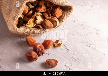 Frutte secche sparse sulla tabella per fare il compote. Disperso dalla borsa Eco, sacco in tessuto. Zero sprechi Foto Stock