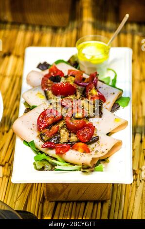 carpaccio di pesce spada con verdure alla griglia e pomodori ciliegini saltati con erbe salate Foto Stock