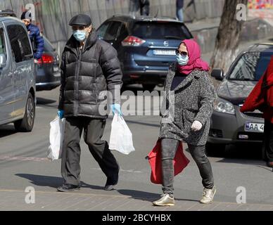 Kiev, Ucraina. 2 aprile 2020. Una coppia che indossa maschere facciali come misura preventiva contro la passeggiata del coronavirus COVID-19 sulla strada.il governo ucraino ha approvato nuove misure di quarantena rinforzate dal 06 aprile 2020 per frenare la diffusione del coronavirus Covid 19, in mezzo ha previsto un picco che è previsto in Ucraina per il 14-15 aprile 2020. Credit: SOPA Images Limited/Alamy Live News Foto Stock