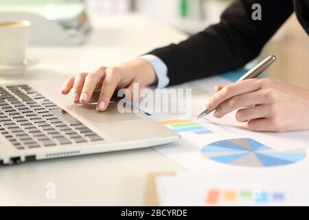 Primo piano di donne dirigenziali mano sul laptop analisi grafici rapporto in ufficio Foto Stock