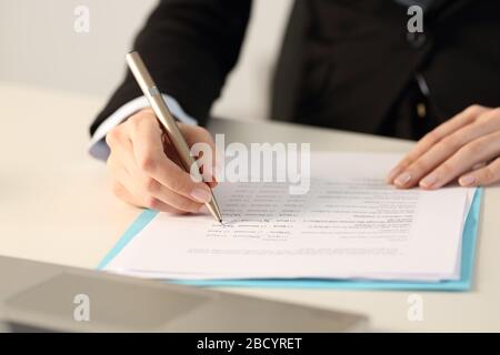 Primo piano delle mani della donna esecutiva compilando il modulo in ufficio Foto Stock