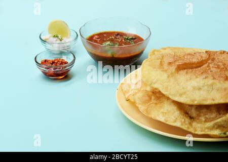 Piatto indiano piccante Chick Peas curry noto anche come Chole Bhatura e Chana Masala, tradizionale pranzo indiano del nord servito con puri fritti o pane piatto Foto Stock