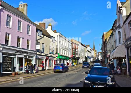 Una vista dell'attraente Monnow Street, Monmouth, una delle principali vie dello shopping in questa trafficata cittadina rurale della contea. Edifici graziosi di color pastello. Foto Stock