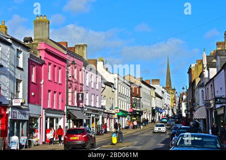Una vista dell'attraente Monnow Street, Monmouth, una delle principali vie dello shopping in questa trafficata cittadina rurale della contea. Edifici graziosi di color pastello. Foto Stock