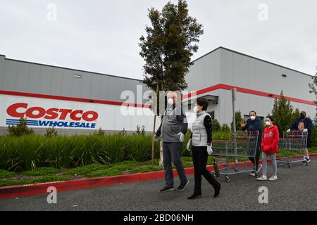 La gente aspetta fuori di un Costco all'ingrosso che ha aperto presto per approvvigionare gli acquirenti che si immagazzina in su sulla scia della pandemia di coronavirus, sabato 4 aprile 2020, a Eastvale, California, Stati Uniti. (Foto di IOS/Espa-Images) Foto Stock