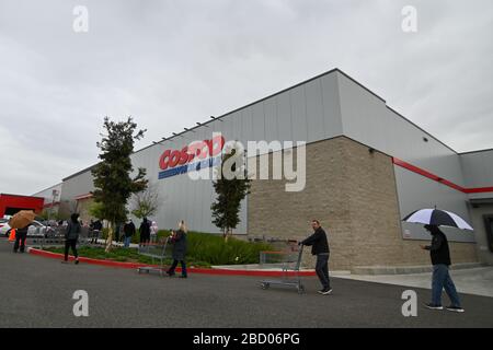 La gente aspetta fuori di un Costco all'ingrosso che ha aperto presto per approvvigionare gli acquirenti che si immagazzina in su sulla scia della pandemia di coronavirus, sabato 4 aprile 2020, a Eastvale, California, Stati Uniti. (Foto di IOS/Espa-Images) Foto Stock