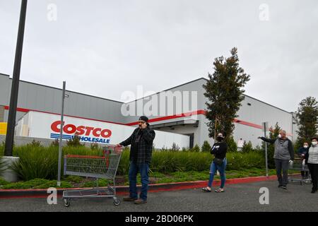 La gente aspetta fuori di un Costco all'ingrosso che ha aperto presto per approvvigionare gli acquirenti che si immagazzina in su sulla scia della pandemia di coronavirus, sabato 4 aprile 2020, a Eastvale, California, Stati Uniti. (Foto di IOS/Espa-Images) Foto Stock