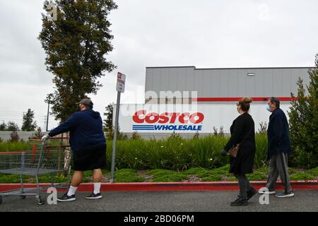 La gente aspetta fuori di un Costco all'ingrosso che ha aperto presto per approvvigionare gli acquirenti che si immagazzina in su sulla scia della pandemia di coronavirus, sabato 4 aprile 2020, a Eastvale, California, Stati Uniti. (Foto di IOS/Espa-Images) Foto Stock