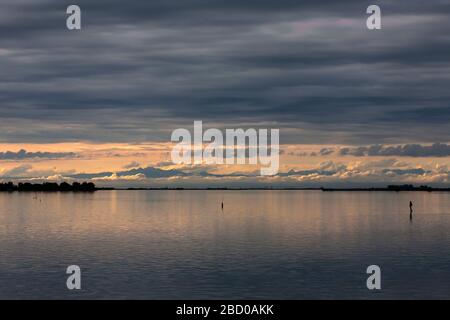 Tramonto sulla Laguna di grado, con le Dolomiti oltre, Friuli-Venezia Giulia, Italia Foto Stock