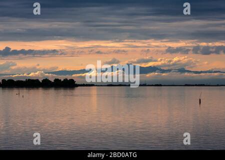 Tramonto sulla Laguna di grado, con le Dolomiti oltre, Friuli-Venezia Giulia, Italia Foto Stock