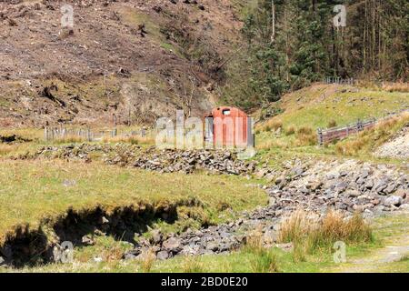 Vecchio fienile arrugginito illuminato dal sole in un Glen Scozzese Foto Stock