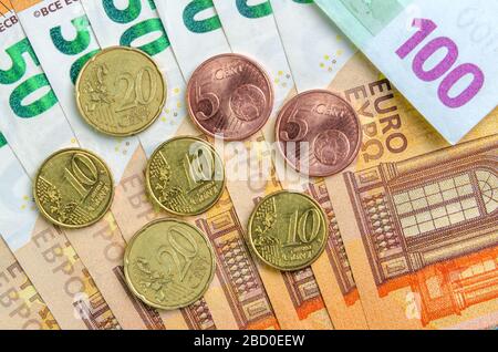 I centesimi di euro sono contenuti in 50 banconote in euro, mentre le banconote in moneta europea sono un'immagine di sfondo. Primo piano della vista superiore. Stipendio, risparmio, cri economici dell'Unione europea Foto Stock
