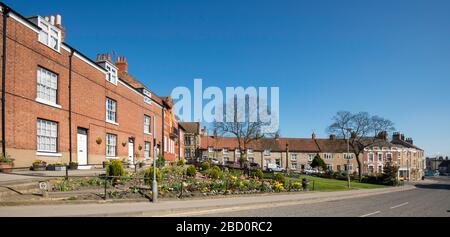 Smiddy Hill nel centro di Pickering, nel North Yorkshire, con attraenti case a schiera intorno allo spazio aperto e aiuole di fiori Foto Stock