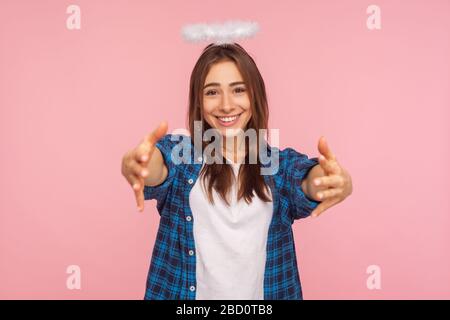 Ritratto di tipo positivo ragazza con nimbus sopra la testa allungare le braccia a macchina fotografica con amichevole sorriso generoso, andando ad abbracciare, condividere l'amore e la cura. Foto Stock